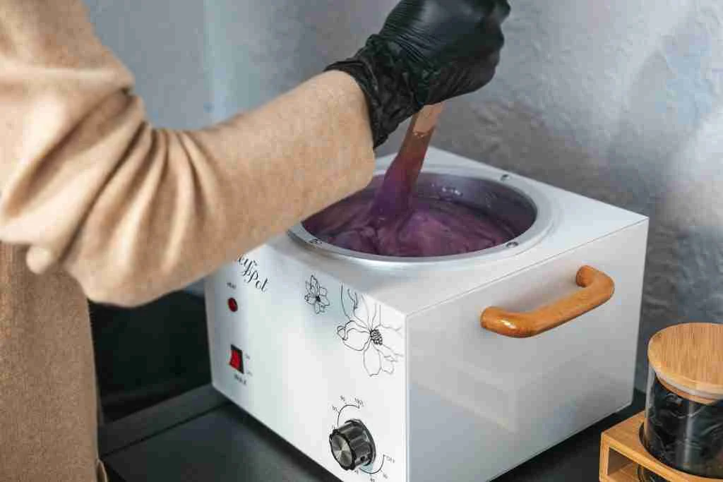 Gloved hand preparing wax at Lily Pad Spa – expert care for sensitive waxing areas